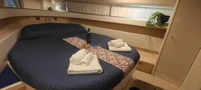 a small bed in a boat with an umbrella and towels at Desirè Charming House Boat in Palermo