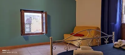 a bedroom with a bed and a window and a chair at Casa Samu in Palermo