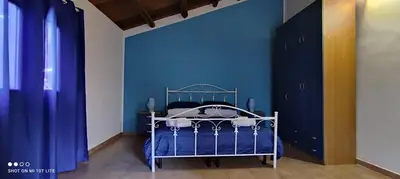 a bedroom with a blue wall and a bed at Casa Samu in Palermo