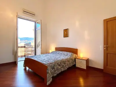 a bedroom with a bed and a large window at Elegante appartamento in centro in Palermo