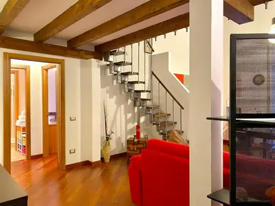 a living room with a red couch and stairs at Elegante appartamento in centro in Palermo