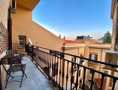 a balcony with a table and chairs and a view at Elegante appartamento in centro in Palermo
