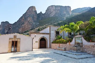 a house with a mountain in the background at Cala Dell'Arena in Macari