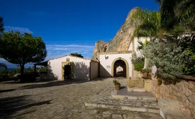 an old building with a stone wall and a tree at Cala Dell'Arena in Macari