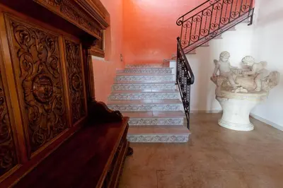 a staircase in a house with a statue on the wall at Cala Dell'Arena in Macari