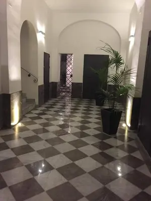 a lobby with a checkered floor and potted plants at Marilù in Palermo