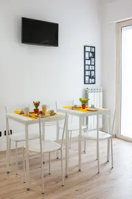 a dining room with two white tables and chairs at Darrè in Palermo