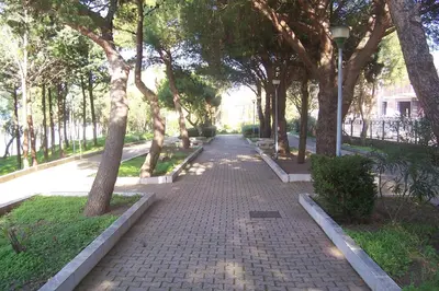 a brick path with trees and a light pole at Villetta in Centro Storico in Caccamo