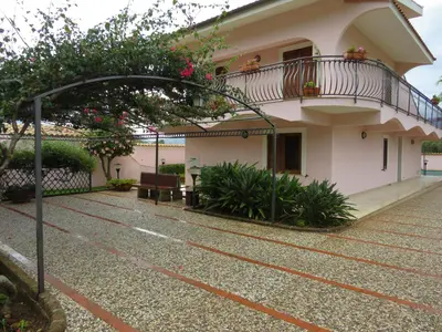 a building with a balcony on the side of it at Villa Rosada in Castellammare del Golfo