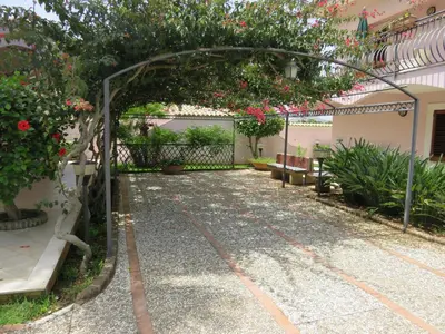 a garden with an arbor with flowers and plants at Villa Rosada in Castellammare del Golfo
