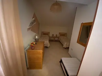 a room with two beds and a table and a couch at Villa Rosada in Castellammare del Golfo