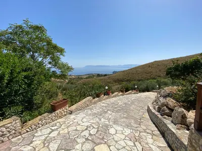 a stone path with people walking down a hill at Casale Giulietta in Scopello