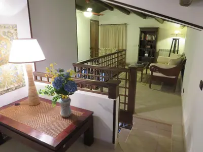 a living room with a staircase and a table with a lamp at Casale Giulietta in Scopello