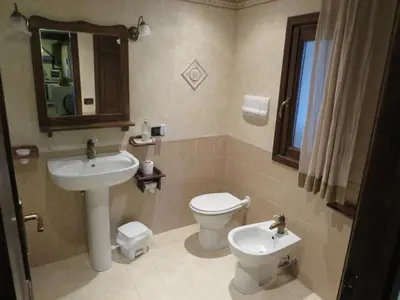 a bathroom with a sink and a toilet and a mirror at Casale Giulietta in Scopello