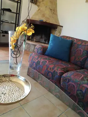 a living room with a couch and a vase of flowers at Villa Mediterranea in Scopello