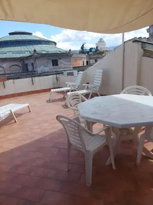 a table and chairs on a roof with an umbrella at Bed & Breakfast Sweet Politeama in Palermo
