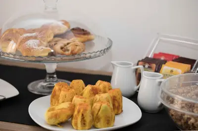a table with a plate of pastries and a tray of donuts at Le Quattro Stagioni - Rooms & Suites in Palermo