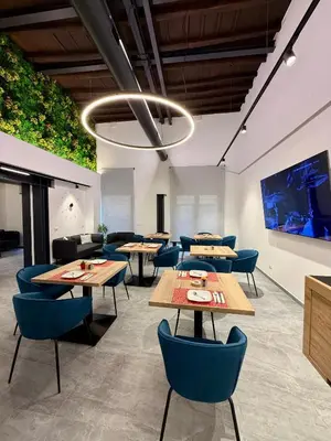 a dining room with tables and blue chairs at Le Quattro Stagioni - Rooms & Suites in Palermo