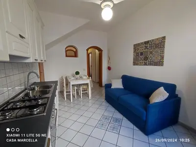 a living room with a blue couch in a kitchen at Casa Marcella San Vito Lo Capo in San Vito lo Capo