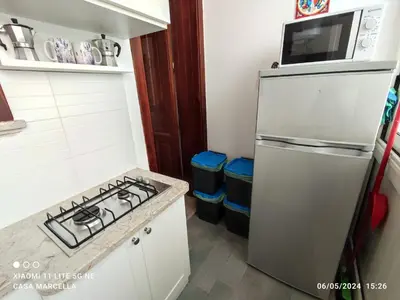 a small kitchen with a stove and a microwave at Casa Marcella San Vito Lo Capo in San Vito lo Capo