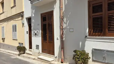 a building with a wooden door on a street at Casa Marcella San Vito Lo Capo in San Vito lo Capo