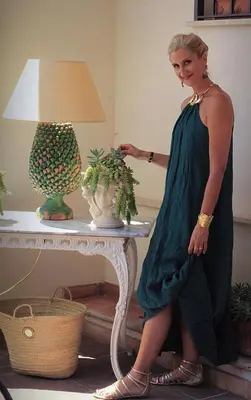 a woman in a dress standing next to a table at Guest House Antichi Ulivi in Mondello