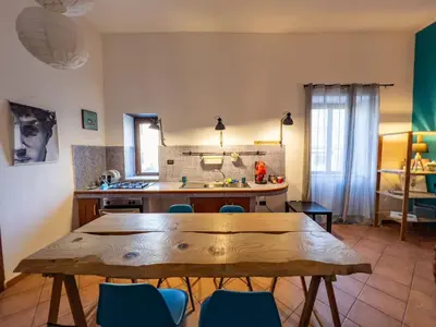 a kitchen with a wooden table and blue chairs at GiuiuzzaMia in Palermo