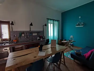 a kitchen with a wooden table and blue walls at GiuiuzzaMia in Palermo