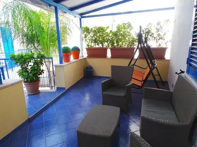 a balcony with chairs and a table and plants at Al Baglio in Mondello