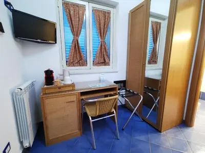 a room with a desk with a chair and a tv at Al Baglio in Mondello
