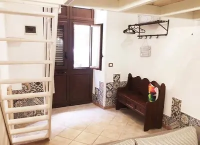 a living room with a couch and a stair case at Alice's Apartment in Castellammare del Golfo