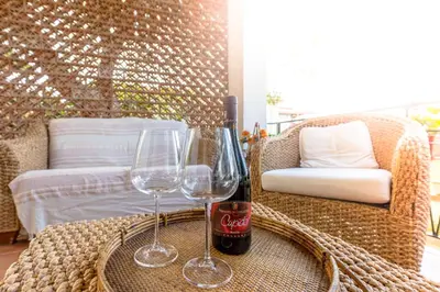 a table with two glasses and a bottle of wine at Villa Violetta in Carini