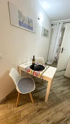 a table and a chair with a bottle of wine at Camerini di Santa Cecilia in Palermo