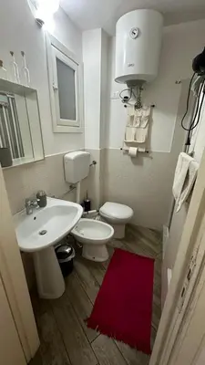 a bathroom with a white sink and a toilet at Camerini di Santa Cecilia in Palermo