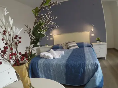 a bedroom with a bed with a blue comforter at I Vicini della Cattedrale in Palermo