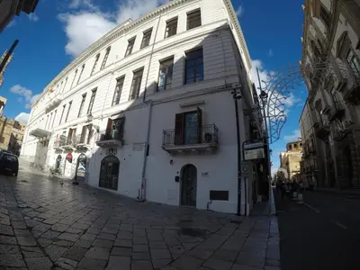 a white building on the side of a street at I Vicini della Cattedrale in Palermo