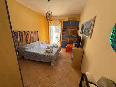 a bedroom with a bed and a table in it at Ashur apartments in Mondello