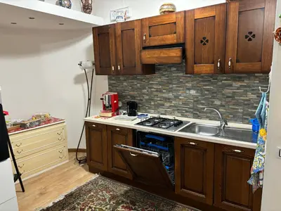 a kitchen with wooden cabinets and a sink at Ashur apartments in Mondello