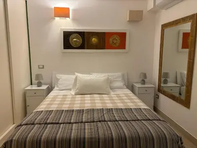 a bedroom with a bed with a checkered blanket at Ashur apartments in Mondello