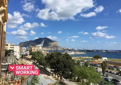 a sign that reads smart working on a city street at Amazing Sea View in Historic Building in Downtown by Wonderful Italy in Palermo
