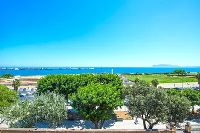 a view of a park with trees and the ocean at Amazing Sea View in Historic Building in Downtown by Wonderful Italy in Palermo