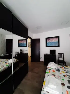 a bedroom with two beds and a desk in it at Casa degli Artisti San Lorenzo in Mezzojuso