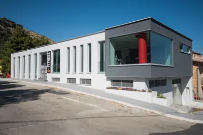 a white building with a red object in the window at Casa degli Artisti San Lorenzo in Mezzojuso
