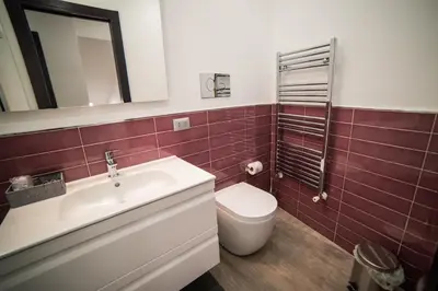 a bathroom with a sink and a toilet and a mirror at Casa degli Artisti San Lorenzo in Mezzojuso