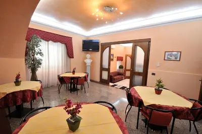 a restaurant with tables and chairs and a tv on the ceiling at Hotel Piccolo in Termini Imerese