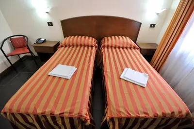 two beds in a hotel room with plates on them at Hotel Piccolo in Termini Imerese