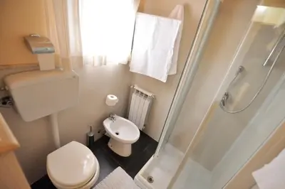 a small bathroom with a toilet and a shower at Hotel Piccolo in Termini Imerese