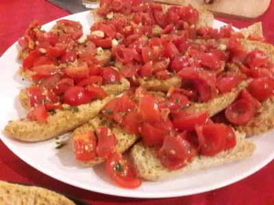 a plate of toast with tomatoes on it at Ad Hoc Rooms in Palermo
