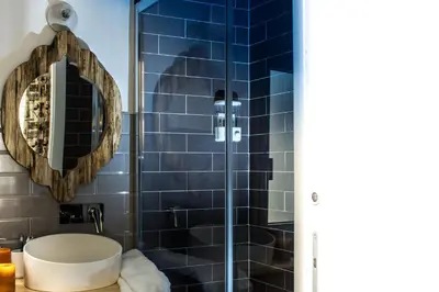 a bathroom with a shower with a sink and a mirror at Ad Hoc Rooms in Palermo