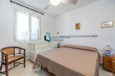 a bedroom with a bed and a chair and a window at Villa Limuti con piscina condominiale in Campofelice di Roccella